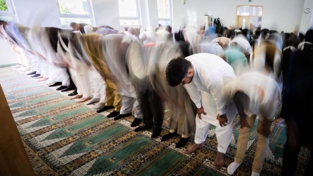 Gläubige beten in einer Moschee im Gebetssaal, während sie sich gemeinsam verbeugen.