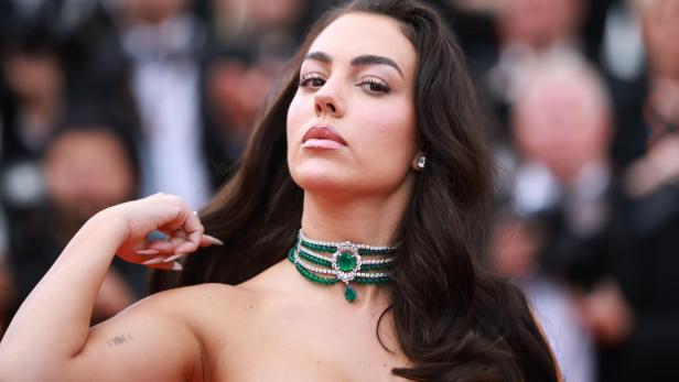 Georgina Rodríguez trägt eine auffällige Smaragd-Halskette mit Diamanten vor einem unscharfen Hintergrund.