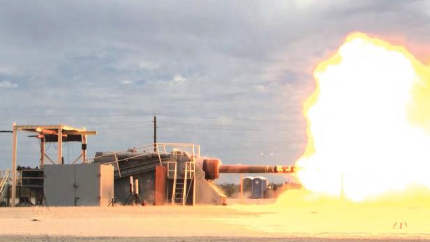Kanone auf Testgelände feuert eine riesige helle Explosion aus der Mündung.