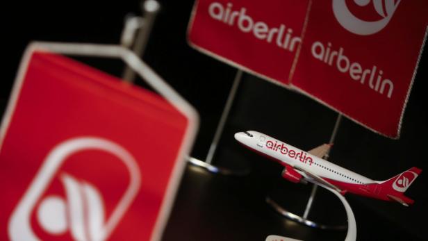 Ein Modellflugzeug von Air Berlin steht vor zwei kleinen Air-Berlin-Flaggen.