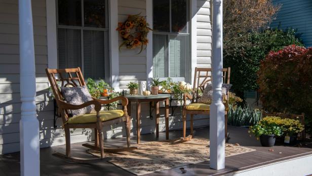 Geschmückte Veranda mit zwei Schaukelstühlen und Herbstdekoration.