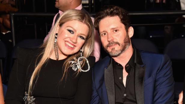 Kelly Clarkson sitzt neben ihrem damaligen Ehemann Brandon Blackstock bei einer Veranstaltung.