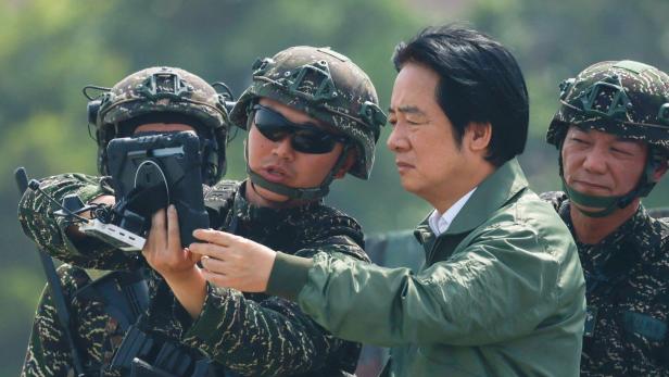 Lai Ching-te betrachtet gemeinsam mit taiwanesischen Soldaten in Tarnuniform ein Tablet.