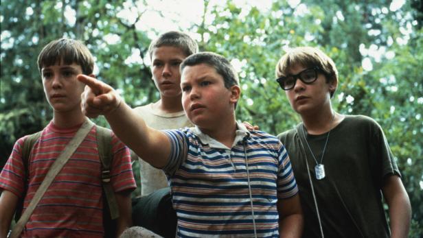Vier Jungen stehen im Wald, wobei einer von ihnen in die Ferne zeigt, eine Szene aus dem Film Stand by Me.