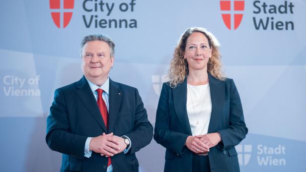 Michael Ludwig und Judith Pühringer stehen vor einer Wand mit dem Logo der Stadt Wien.