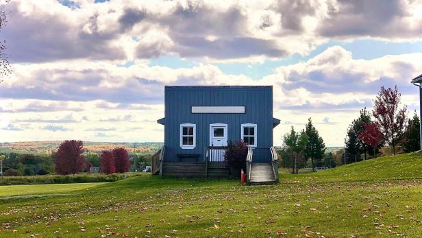 Blaues Tiny House auf einer Wiese