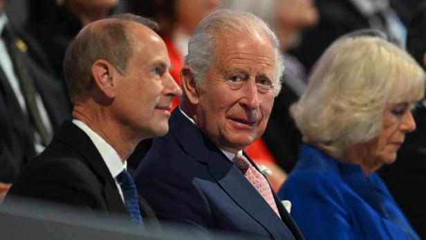 König Charles III. sitzt neben Prinz Edward und Königin Camilla bei einer öffentlichen Veranstaltung.