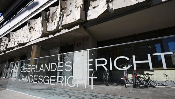 Die Glasfront vor dem Gebäude zeigt die Aufschrift „Oberlandesgericht Landesgericht“ mit dem österreichischen Bundesadler.