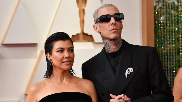 Kourtney Kardashian und Travis Barker halten Händchen auf dem roten Teppich der Oscar-Verleihung.