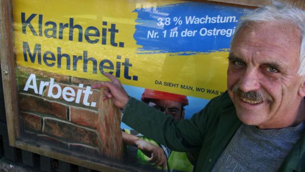 Ein Mann vor einem Plakat