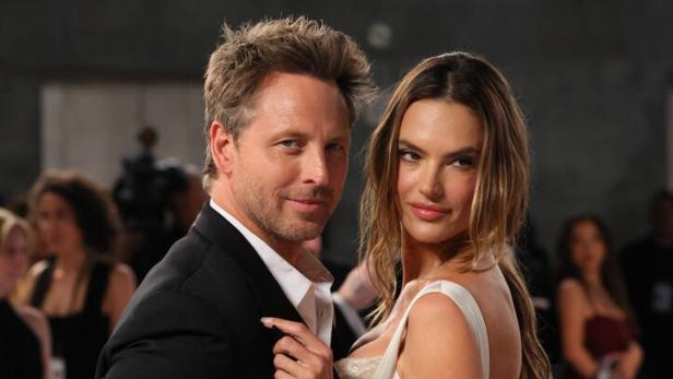 Buck Palmer und Alessandra Ambrosio posieren eng umschlungen auf einem roten Teppich.