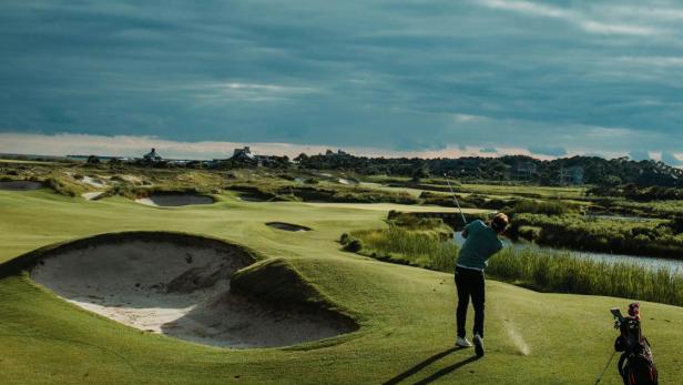 „Mann spielt während eines herannahenden Gewitters Golf am Golfplatz