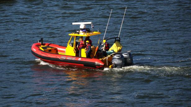 Ein rot-gelbes Boot, das einen Fluss hinunterfährt