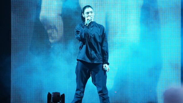 Die neuseeländische Singer/Songwriterin Lorde in blauem Licht auf einer Bühne