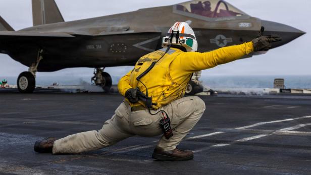 A U.S. sailor launches an F-35C Lightning II from the flight deck of Nimitz-class aircraft carrier USS Abraham Lincoln