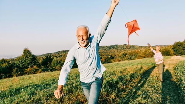 woman man outdoor senior couple happy lifestyle retirement together smiling love kite run nature mature