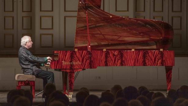 Andras Schiff spielt auf einem knallroten Mahagoni-Klavier