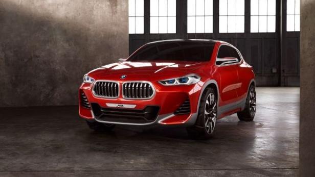 Ein roter BMW X2 steht in einer Garage vor einem Fenster.