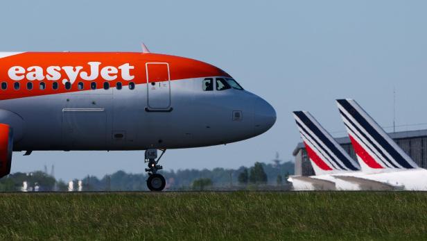 easyJet-Flugzeug am Rollfeld, daneben zwei Air-France-Leitwerke.