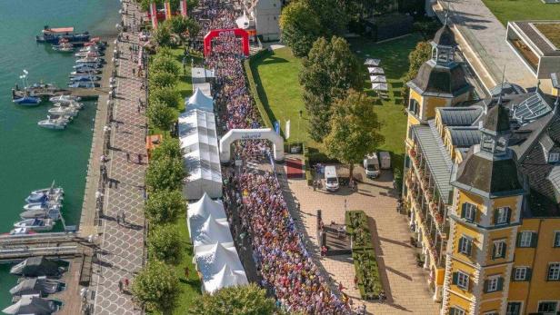 Eine Menschenmenge läuft bei einem Marathon am Ufer des Wörthersees in Velden am Wörthersee entlang.