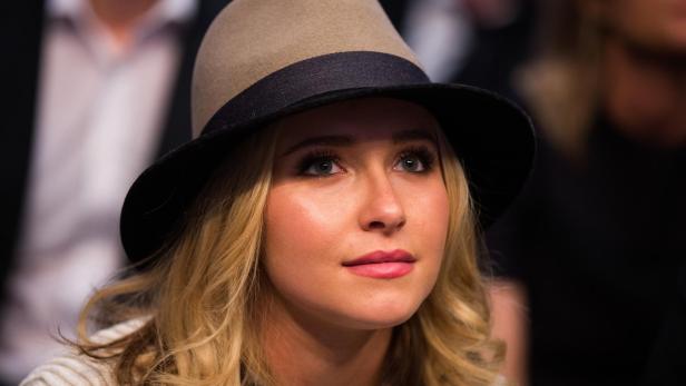 Hayden Panettiere mit einem beigefarbenen Hut mit schwarzem Band blickt aufmerksam nach oben.