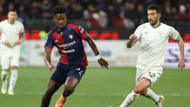 Ein Spieler von Cagliari Calcio führt den Ball im Zweikampf gegen einen Akteur von Lazio Rom auf dem Fußballfeld.