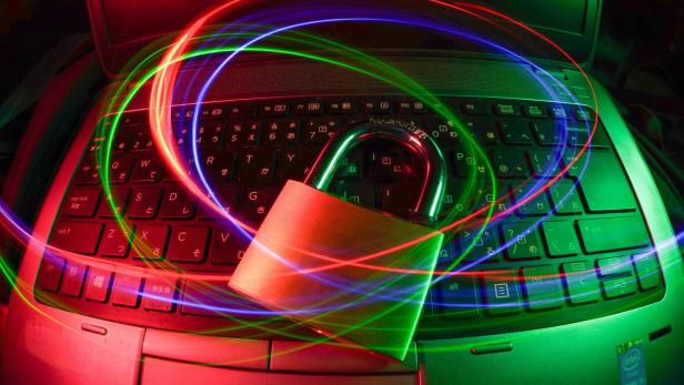 Laptopschloss auf beleuchteter Tastatur mit Lichtspuren.
