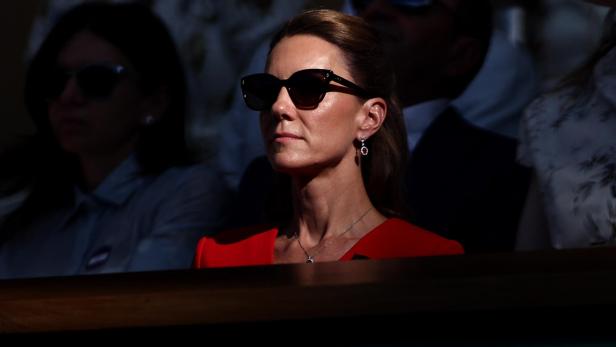 Catherine, Prinzessin von Wales, trägt eine Sonnenbrille und ein rotes Kleid bei einem öffentlichen Auftritt.