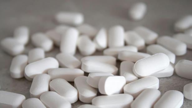 Weiße Tabletten liegen auf einer Oberfläche.