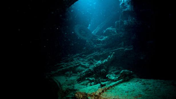 Unterwasserhöhle mit Taucherseil und blauem Licht.