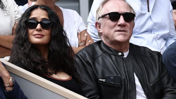 Salma Hayek und François-Henri Pinault sitzen nebeneinander auf der Tribüne und tragen beide eine Sonnenbrille.