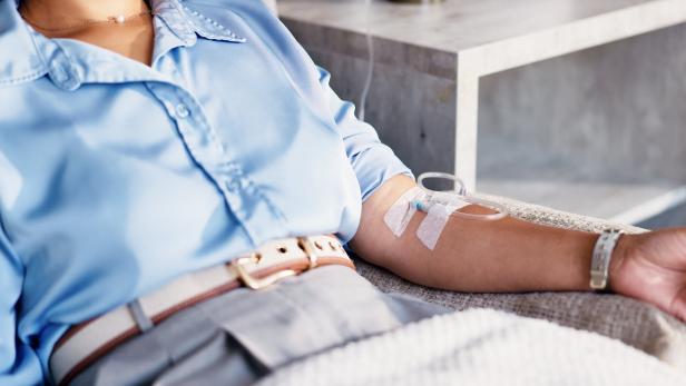 Eine Frau liegt auf einer Liege und erhält eine Infusion.