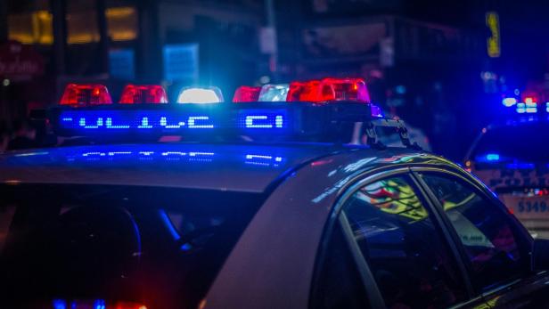 Polizeiauto mit blinkendem Blaulicht bei Nacht.