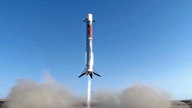 Ein Booster einer Rakete setzt zur Landung vor blauem Himmel an