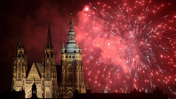 Rote Feuerwerkskörper erhellen den Himmel über der Prager Burg.