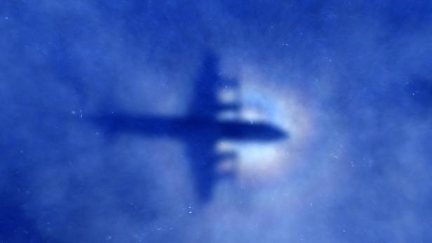 Der Schatten eines Flugzeugs vor einem blauen Himmel.