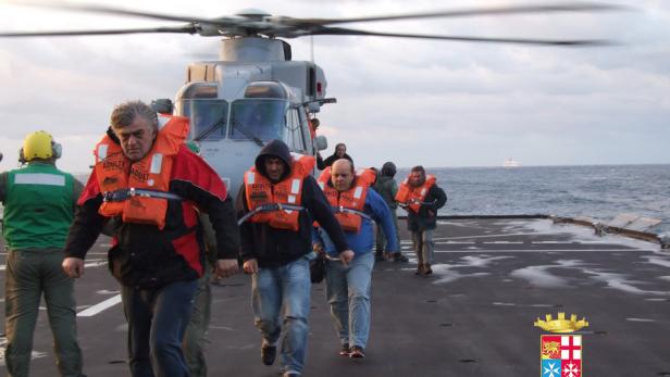 Eine Gruppe von Personen in Schwimmwesten verlässt einen Hubschrauber auf einem Schiff.