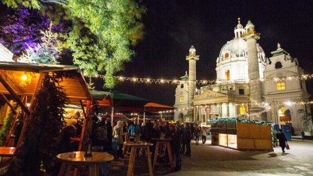 Der Weihnachtsmarkt vor der Karlskirche in Wien bei Nacht.