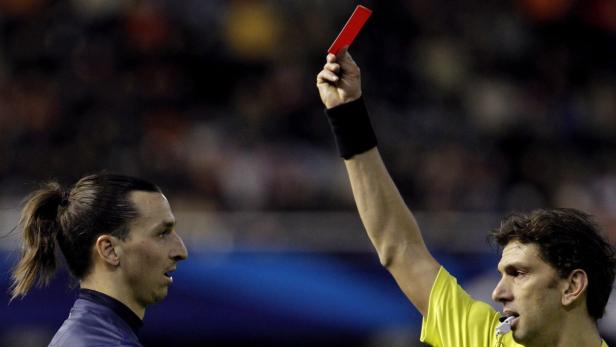 epa03581125 Italian referee Paolo Tagliavento (R) showes the red card to Swedish Zlatan Ibrahimovic (L) of Paris Saint Germain during the UEFA Champions League Round of 16 first leg soccer match played at Mestalla stadium, in Valencia, eastern Spain, 12 February 2013. EPA/Juan Carlos Cardenas