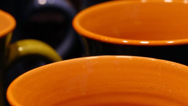 Nahaufnahme von orangefarbenen Keramiktassen.