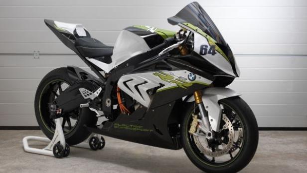 Ein weißes, schwarzes und grünes BMW-Elektromotorrad steht in einer Garage.