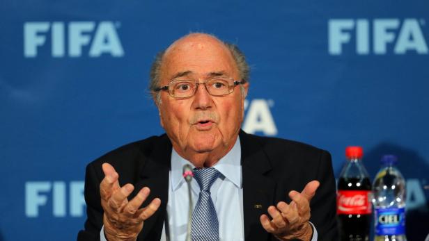 Sepp Blatter bei einer Pressekonferenz vor einem FIFA-Hintergrund.