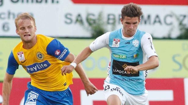 Zwei Fußballspieler im Zweikampf auf dem Spielfeld.