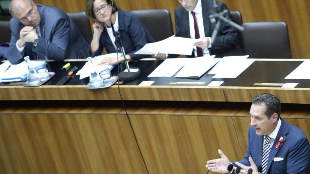 Ein Mann hält eine Rede vor einem Publikum während einer Sitzung.