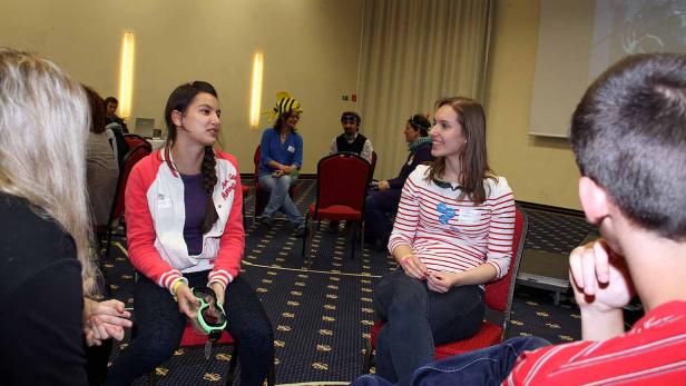 Mehrere Personen sitzen in einem Raum und unterhalten sich.