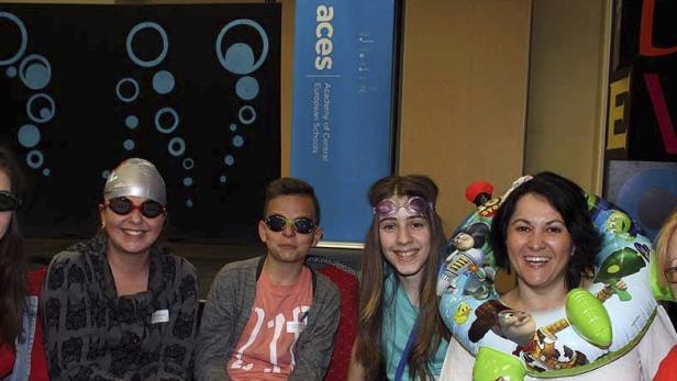 Eine Gruppe von Personen mit Schwimmbrillen und Schwimmreifen posiert für ein Foto.