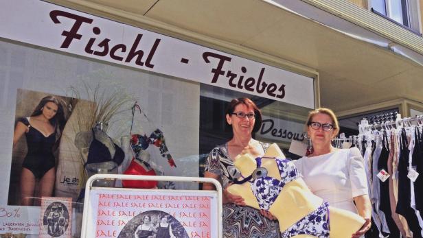 Zwei Frauen präsentieren Bademode vor dem Geschäft „Fischl-Friebes“.