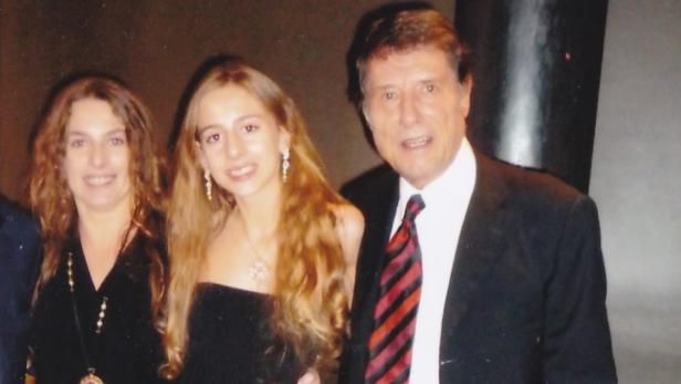 Eine Frau, ein Mädchen und ein Mann in Anzug und Krawatte posieren für ein Foto.