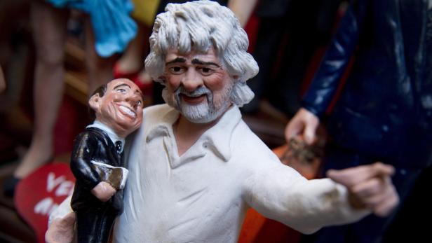 epa03482049 A figurine of Italian comedian Beppe Grillo carrying a small Silvio Berlusconi is pictured in San Gregorio Armeno street in Naples, Italy, 22 November 2012. The street of the historic center of Naples is renowned for the artisan workshops of the nativity scene. EPA/CIRO FUSCO