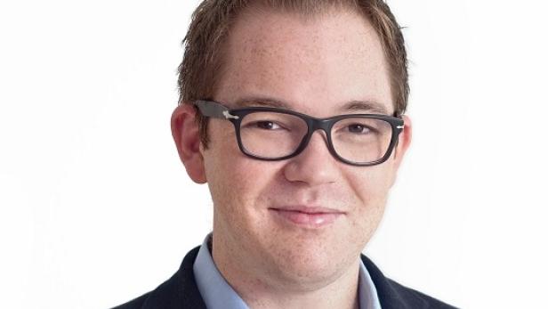 Ein Mann mit Brille lächelt in die Kamera.